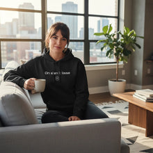 Charger l'image dans la galerie, Femme assise sur un canapé portant un hoodie noir Impressions Gaspésie avec l'inscription On s'en k lisse