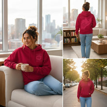 Charger l'image dans la galerie, Femme portant un hoodie rouge cerise Impressions Gaspésie avec impression ton sur ton, style unisexe et confortable.