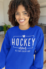 Charger l'image dans la galerie, Femme souriante portant un chandail bleu Impressions Gaspésie avec inscription Hockey Mom en impression DTF blanche

