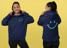 Charger l'image dans la galerie, Modèle portant le hoodie bleu marine Impressions Gaspésie avec motif sourire bleu clair sur la poitrine et le dos
