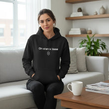 Charger l'image dans la galerie, Femme portant un hoodie noir Impressions Gaspésie avec l'inscription On s'en k lisse, coupe classique et poche kangourou
